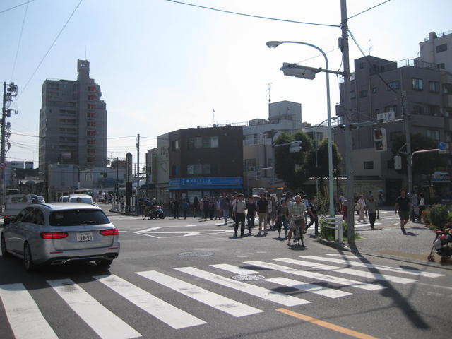 正面にあります青い看板の建物が当社です。左奥に見える白い建物は池上駅です。